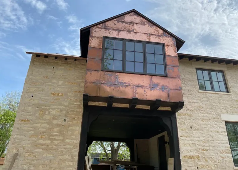 Copper metal panel facade on a stone building for Roof Repair in Waco