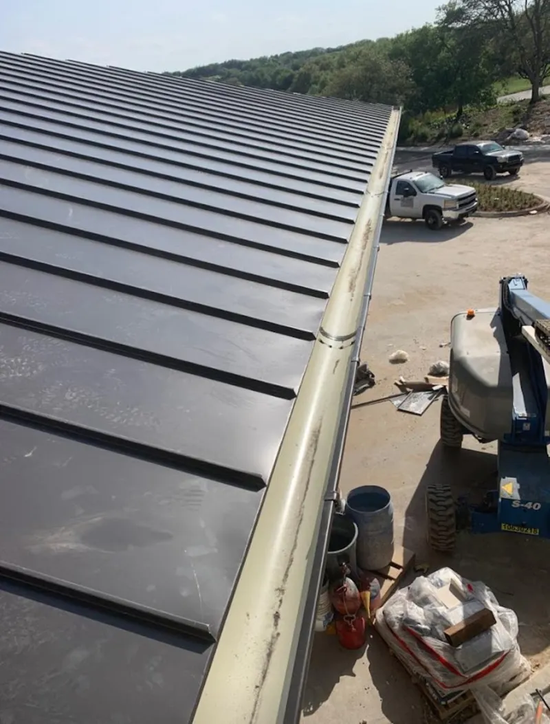 Standing seam panel and gutter detail on a metal roofing jobsite in Waco